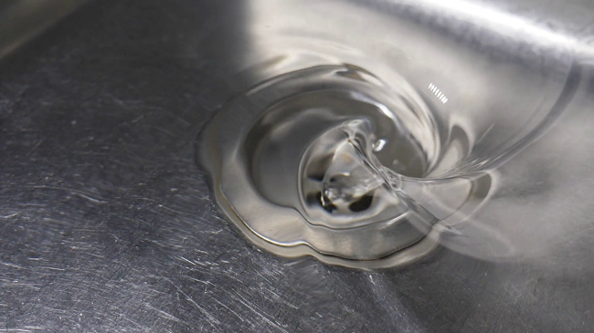Nước thải trong bồn rửa tạo thành vòng xoáy và thoát chậm, vì sao?